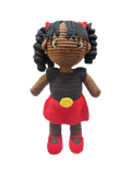 Suzie's Sunshine Dolls Alinta, a hand-crocheted doll with black curly hair, wearing a black top and red skirt with yellow detail, inspired by the Aboriginal flag.