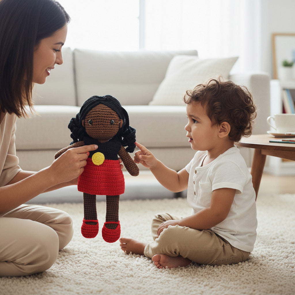 Suzie's Sunshine Dolls Alinta, a hand-crocheted doll with long black curly hair and a red dress, inspired by the Aboriginal flag.