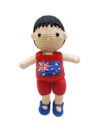 Suzie's Sunshine Dolls Jack, a crocheted doll with short black hair, wearing a red outfit with the Australian flag on the chest and blue shoes.