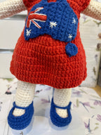 Suzie's Sunshine Dolls Mia, a crocheted doll with long hair, wearing a red dress with Australia flag appliqué and blue shoes.