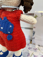 Suzie's Sunshine Dolls Mia, a crocheted doll with long brown hair, wearing a red dress with Australia flag applique and blue shoes.