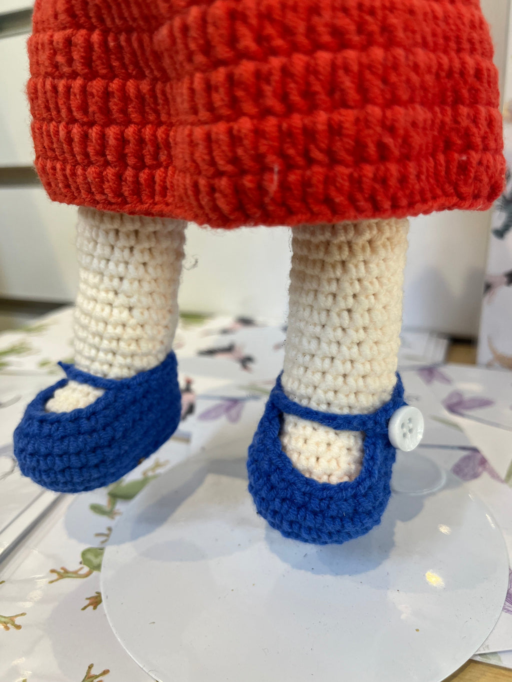 Suzie's Sunshine Dolls Mia, a crocheted doll with long hair, wearing a red dress and blue shoes with white buttons. Features Australian flag details.