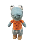 Suzie's Sunshine Dolls Calvin the Croc, a handmade crochet toy with blue snout, orange shirt, and checkered pants.