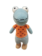 Suzie's Sunshine Dolls Calvin the Croc, a handmade crochet toy with blue snout, orange shirt, and checkered pants.