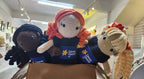 Suzie's Sunshine Dolls hand-crocheted dolls in navy dresses with Cancer Council NT patch. Diverse hair colors: black, orange, blonde.