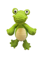 Suzie's Sunshine Dolls Cassius the Croc, a handmade green yarn stuffed toy with a cream belly and big white-rimmed eyes.