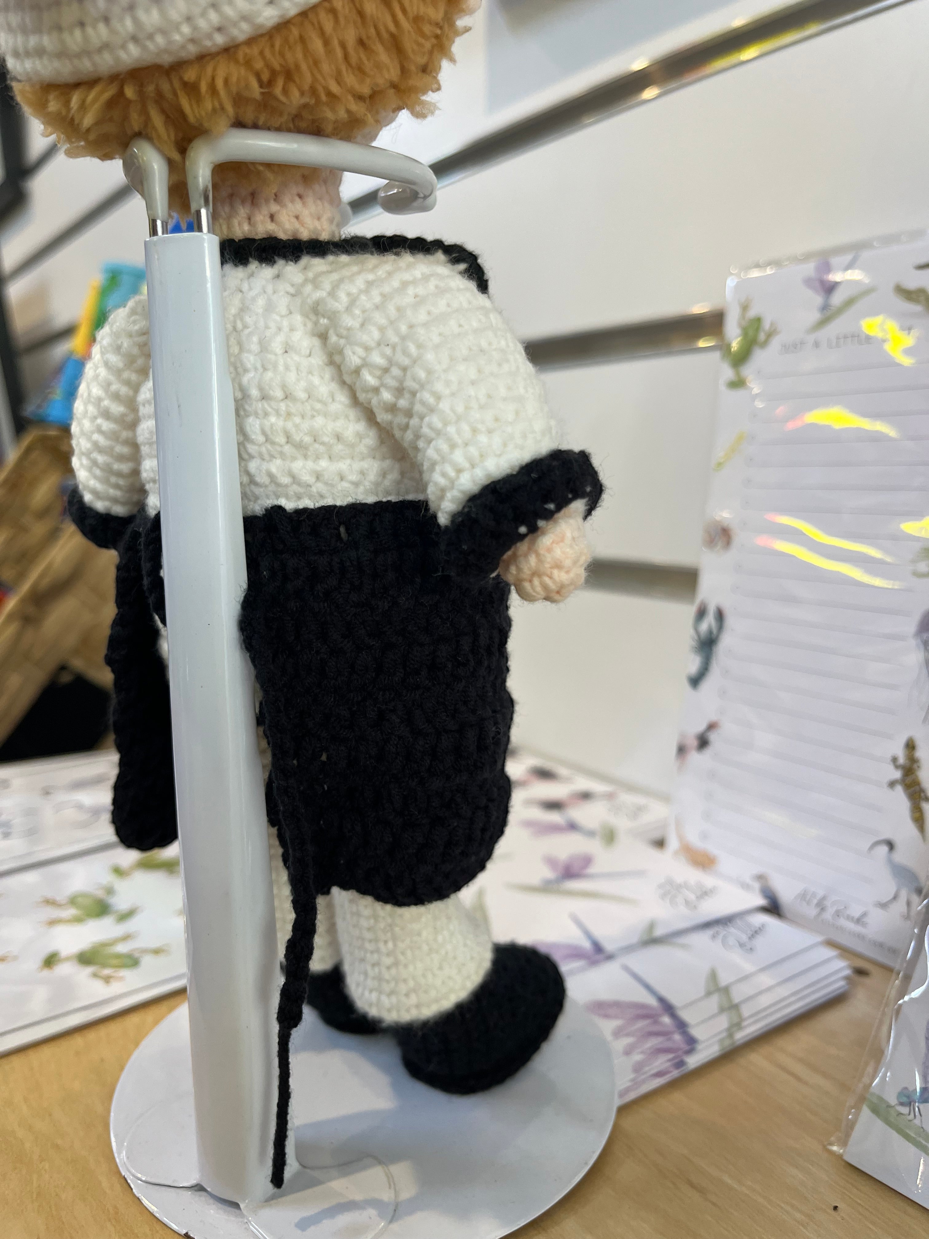 Suzie's Sunshine Dolls handcrafted chef doll in white and black uniform with apron and hat, made from eco-friendly yarn.