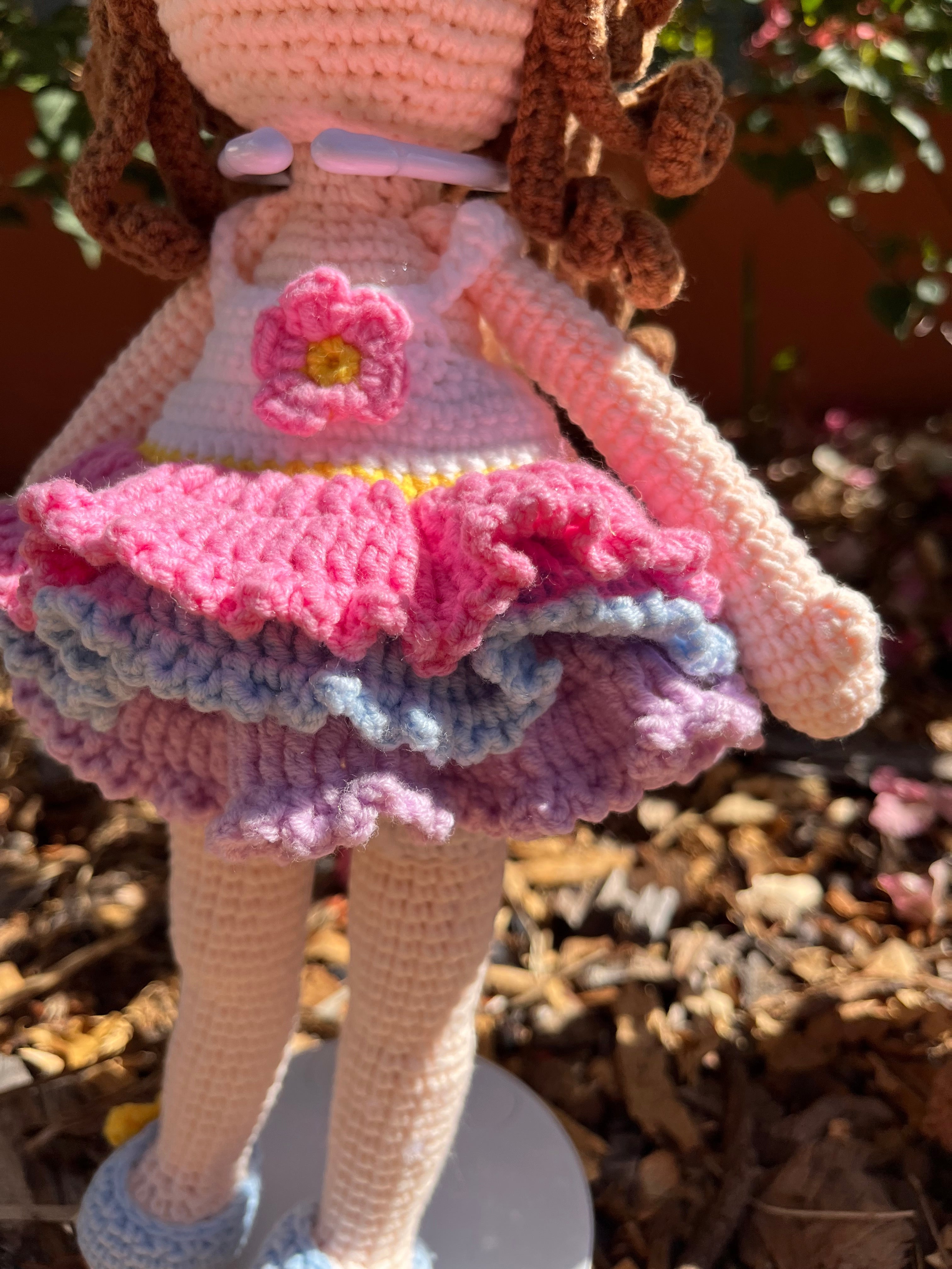 Suzie's Sunshine Dolls Cleo ballerina doll with pink, purple, and blue ruffled dress and brown yarn curls.