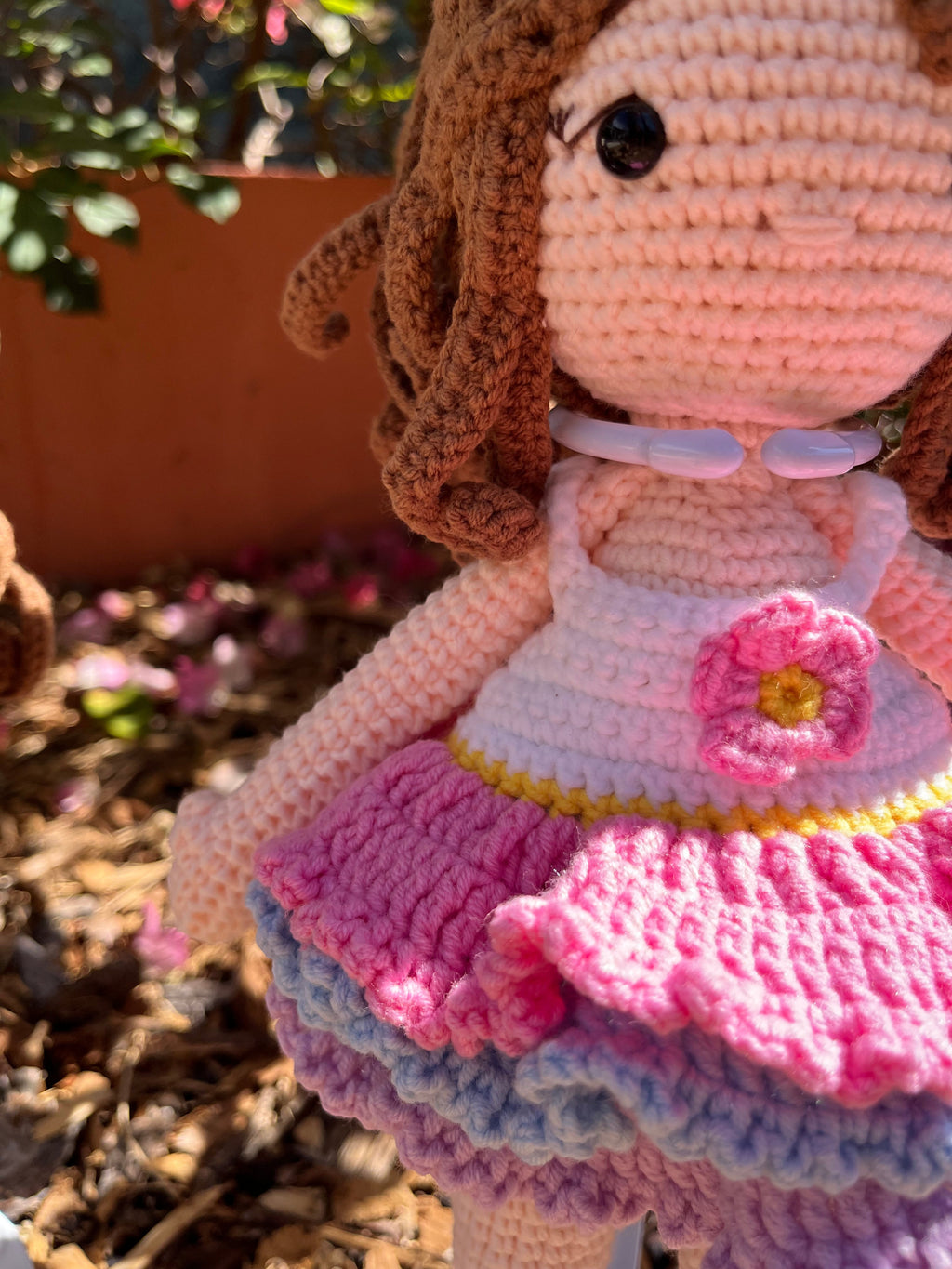 Suzie's Sunshine Dolls Cleo ballerina doll with brown yarn curls, pink, purple, and blue ruffled dress, and flower applique.