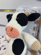 Suzie's Sunshine Dolls Daisy the Cow, a handmade crocheted toy with black and white patches, pink snout, and beige accents.