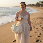 Suzie's Sunshine Dolls cream crochet shell-shaped handbag with braided white leather strap and gold hardware.