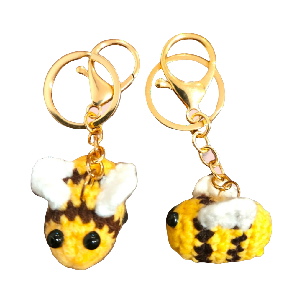 Suzie's Sunshine Dolls handmade crochet bee keychains in yellow, brown, and white yarn with gold clasps.