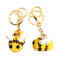 Suzie's Sunshine Dolls handmade crochet bee keychains in yellow, brown, and white yarn with gold clasps.