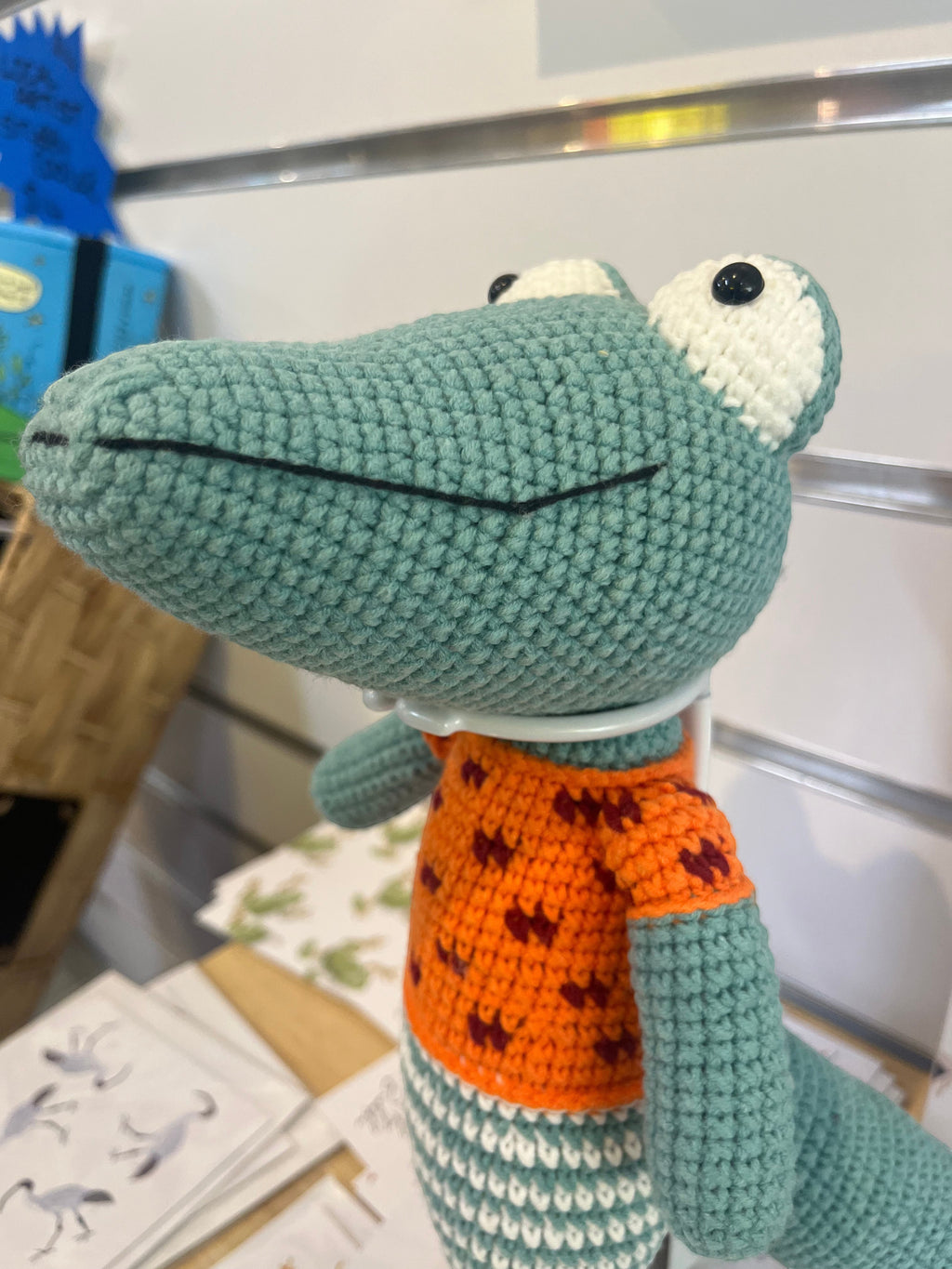 Suzie's Sunshine Dolls Calvin the Croc, a handmade crochet toy with a teal body, orange shirt, and white and teal striped pants.
