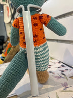 Suzie's Sunshine Dolls Calvin the Croc handmade crochet doll, teal body, orange shirt with maroon spots, striped shorts.