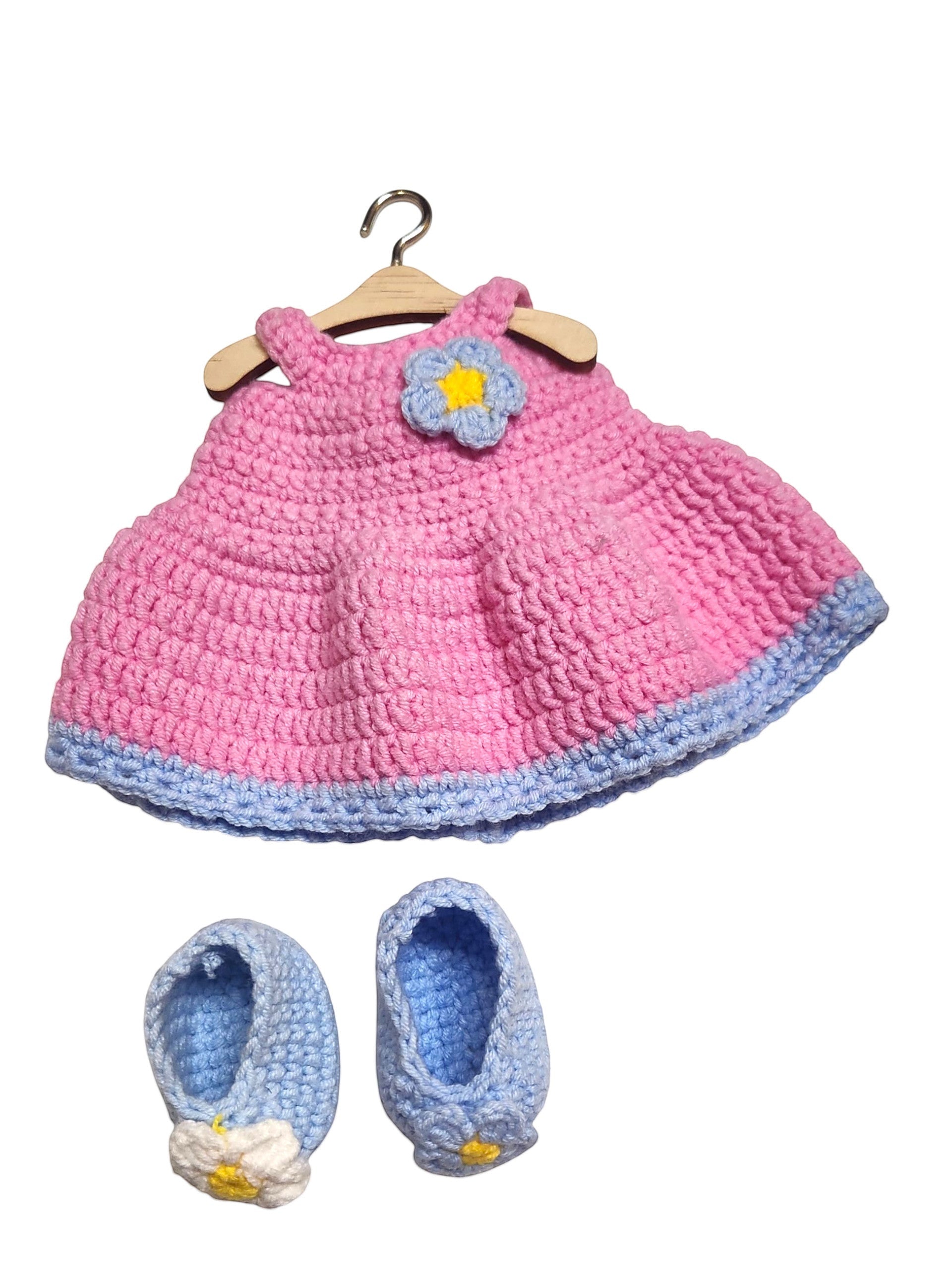 Suzie's Sunshine Dolls pink crochet doll dress with blue trim and flower accent, with matching blue crochet booties.