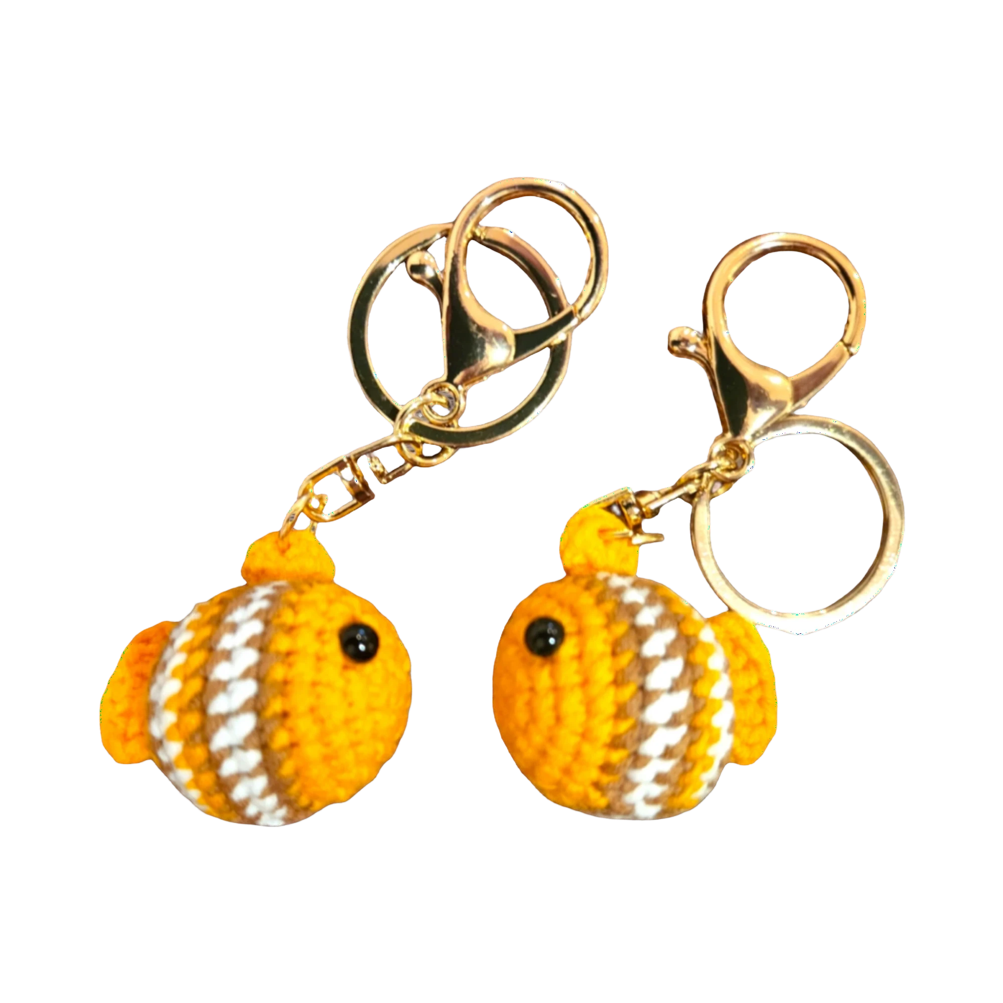 Suzie's Sunshine Dolls handmade crochet fish keychains in orange, white, and brown yarn with gold clasps.