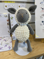 Suzie's Sunshine Dolls handmade grey and cream crochet lamb with bobble stitch belly and a light blue collar.