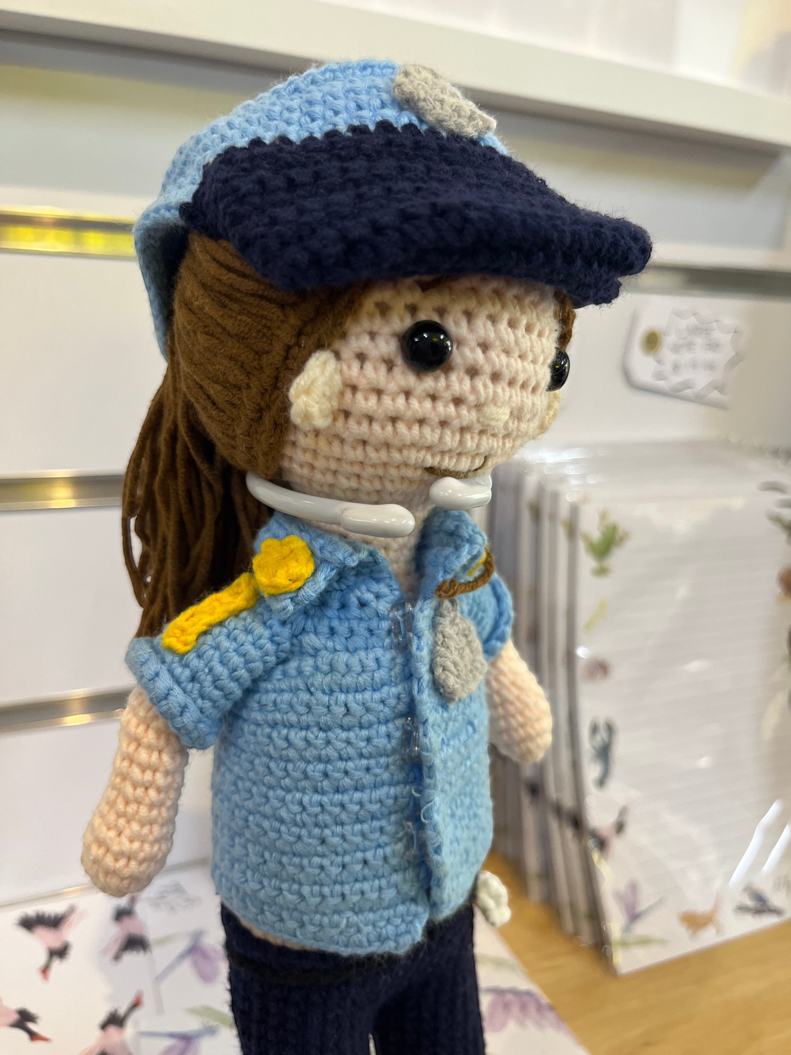 Suzie's Sunshine Dolls handcrafted crochet police officer doll in blue uniform with cap and badge. Approx. 28-30cm tall.
