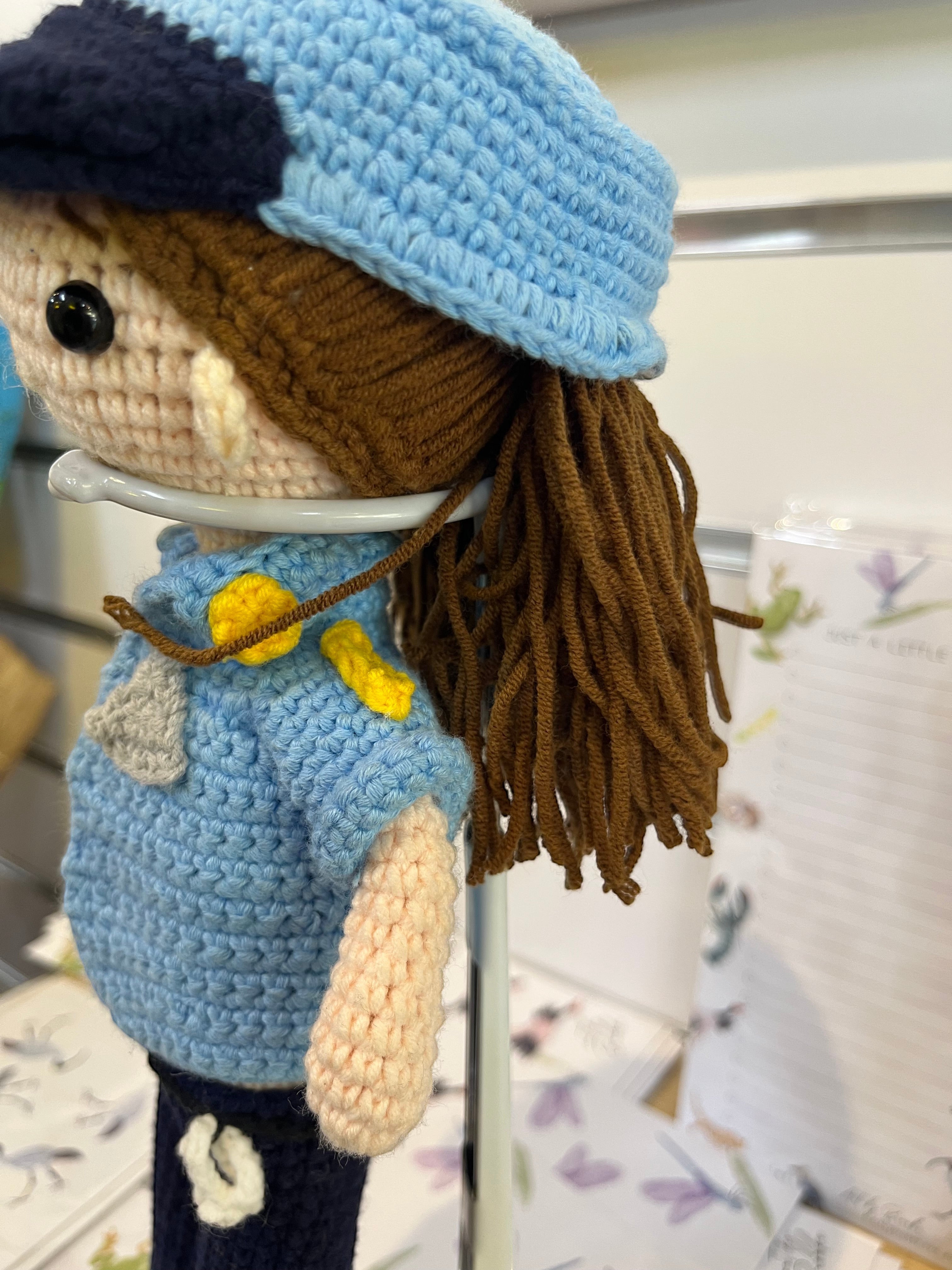 Suzie's Sunshine Dolls handcrafted crochet police officer doll in blue uniform with brown yarn hair.