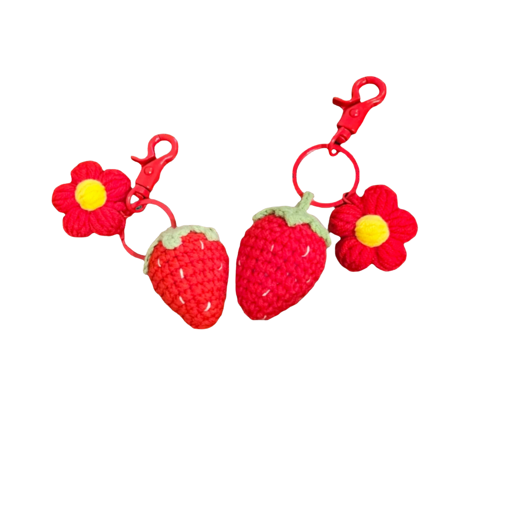 Suzie's Sunshine Dolls handmade crochet strawberry and flower keychains, red yarn with green leaves and yellow center.