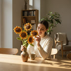Suzie's Sunshine Dolls handcrafted crochet sunflowers in yellow and brown with green leaves in a vase.