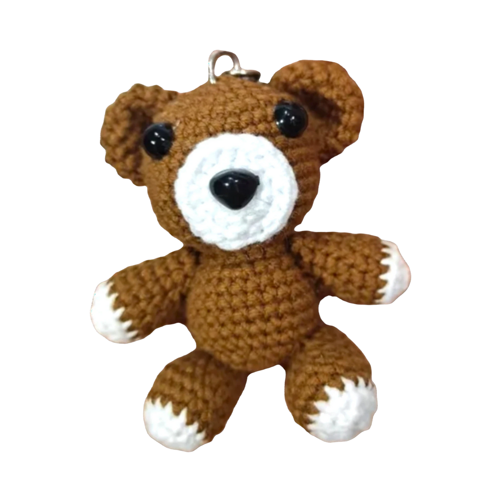 Suzie's Sunshine Dolls brown crochet teddy bear keychain with white accents and black eyes.