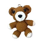 Suzie's Sunshine Dolls brown crochet teddy bear keychain with white accents and black eyes.