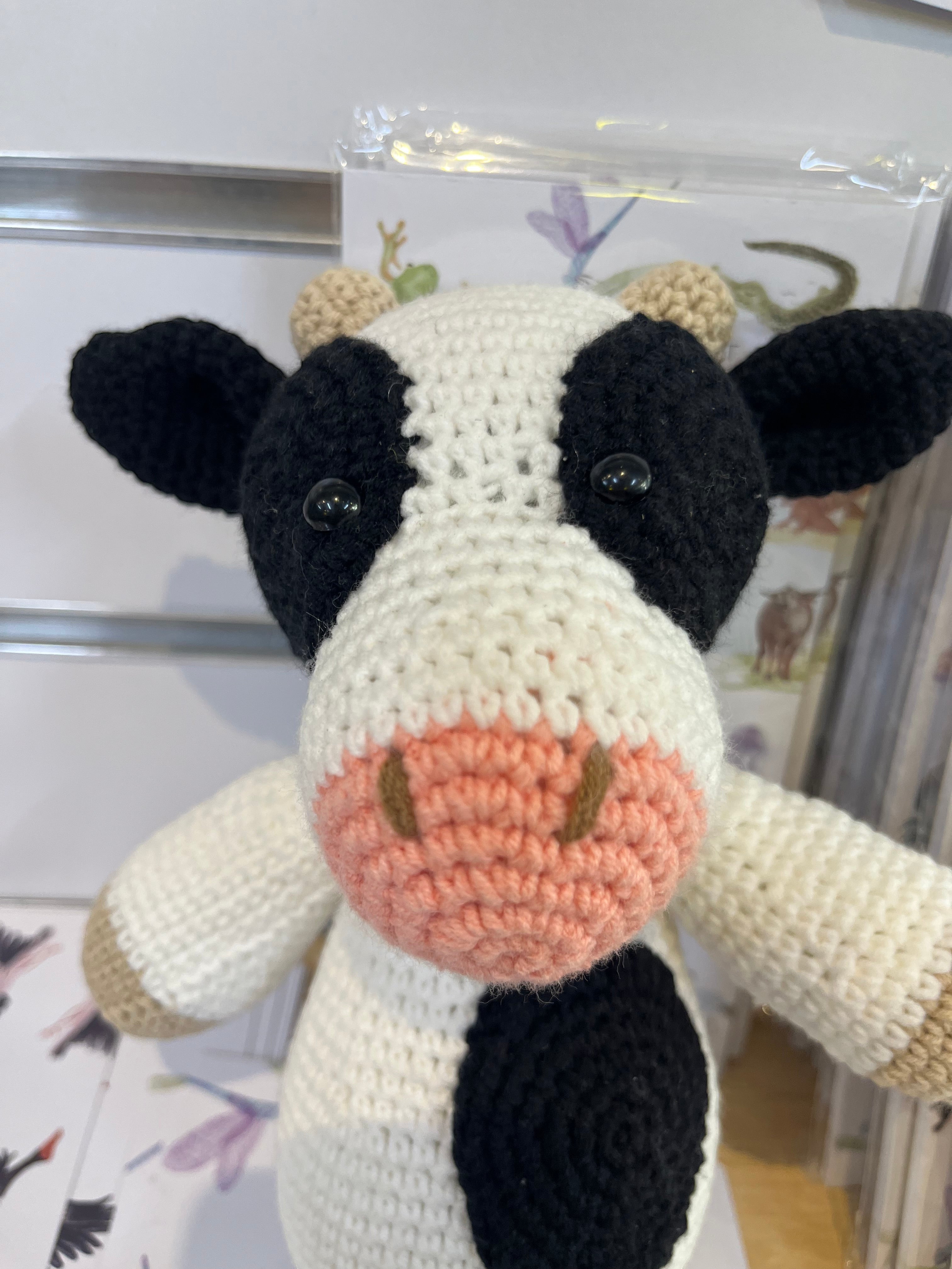 Suzie's Sunshine Dolls handmade crocheted cow toy with black and white spots, pink snout, and beige horns.