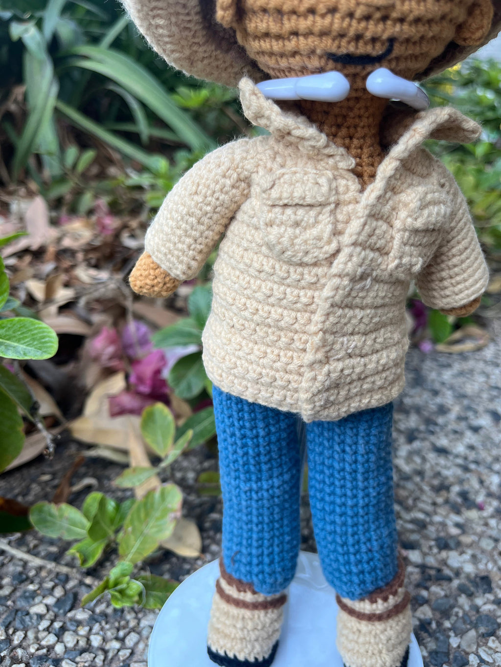 Suzie's Sunshine Dolls crocheted cowboy/cowgirl doll wearing a tan jacket, blue jeans, and a cowboy hat.