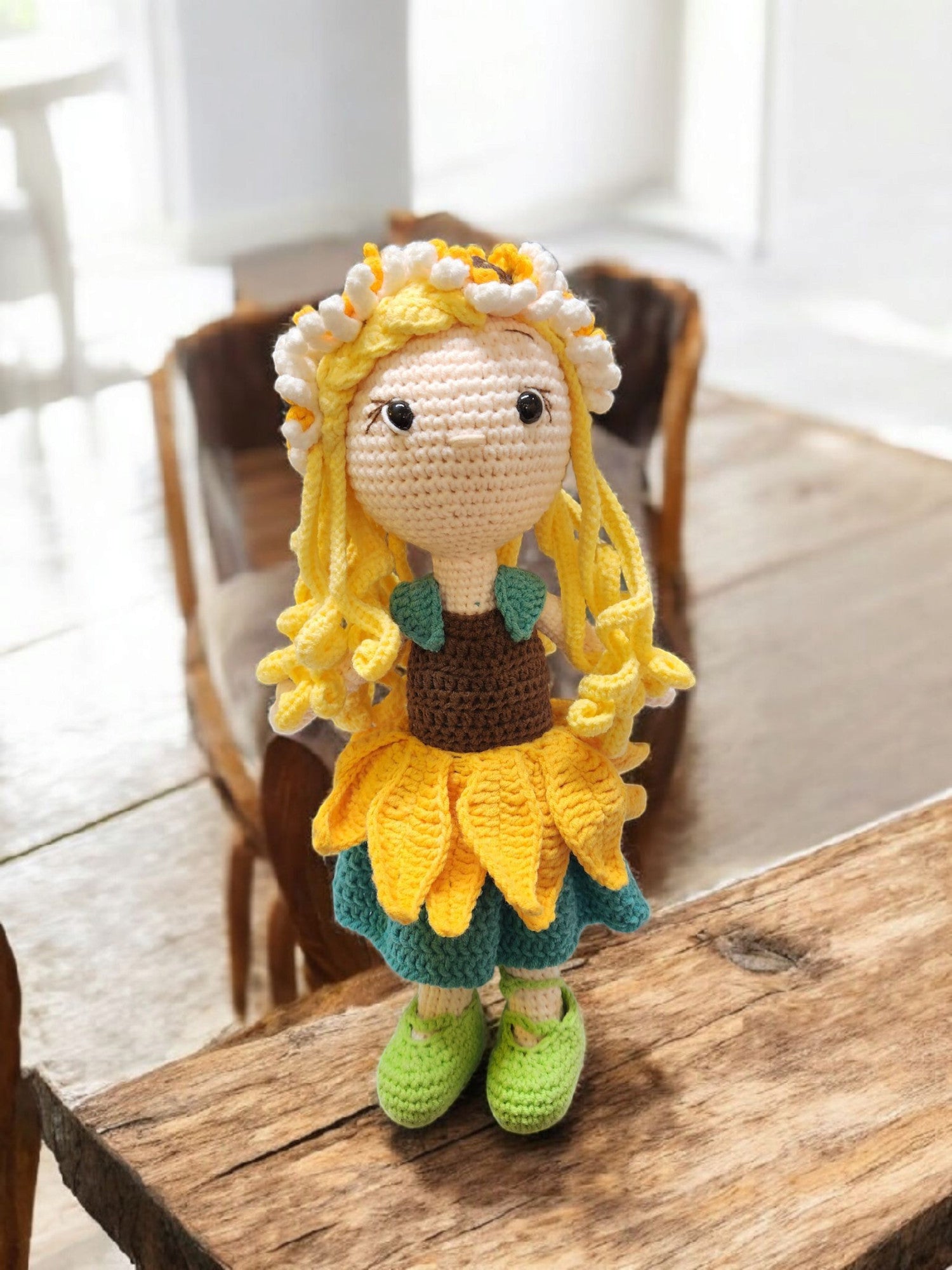 Suzie's Sunshine Dolls Daisy crochet doll with yellow yarn hair, sunflower skirt, and green shoes, wearing a floral crown.