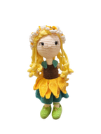 Suzie's Sunshine Dolls Daisy, a crocheted doll with golden yarn hair, wearing a sunflower skirt, green shoes, and a floral crown.