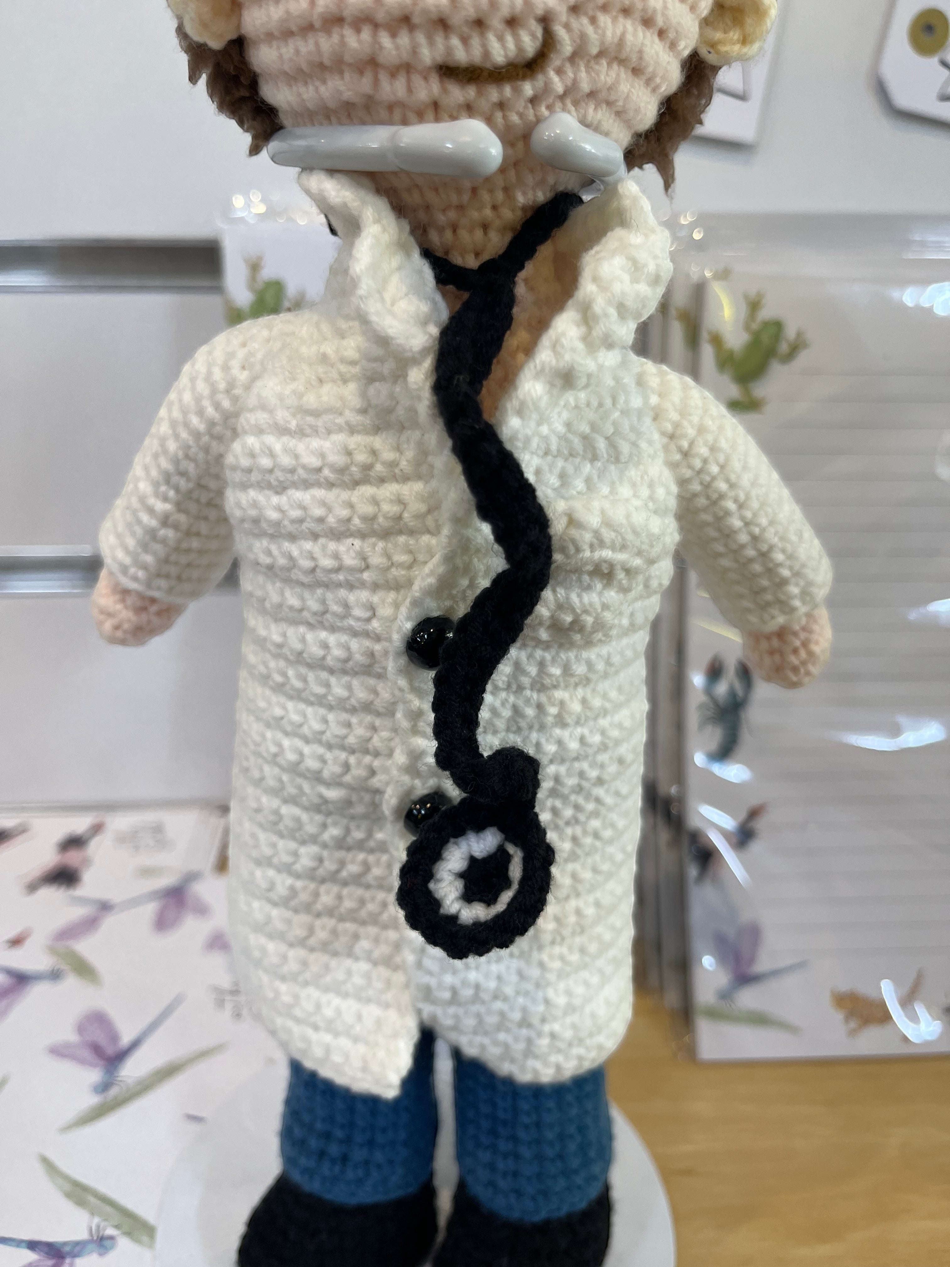Suzie's Sunshine Dolls Doctor Doll, a crochet toy with a white coat, blue pants, and stethoscope.