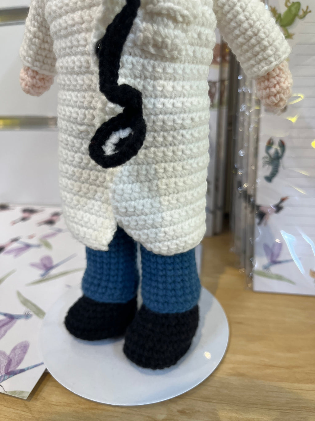 Suzie's Sunshine Dolls Doctor Doll, a crochet toy in a white coat, blue pants, and black shoes, with a stethoscope.