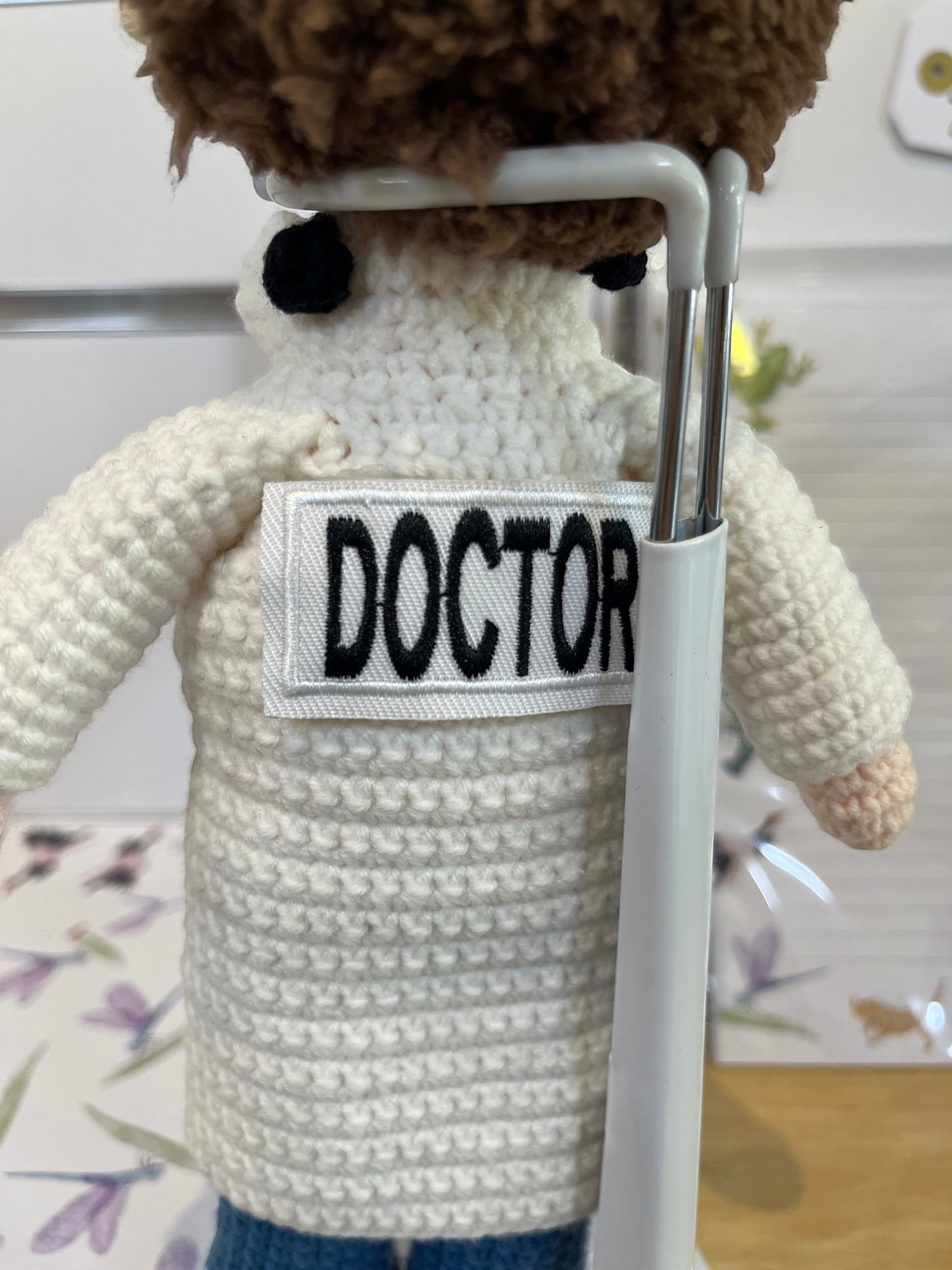 Suzie's Sunshine Dolls white crochet doctor doll with "DOCTOR" patch, blue pants, and brown hair.