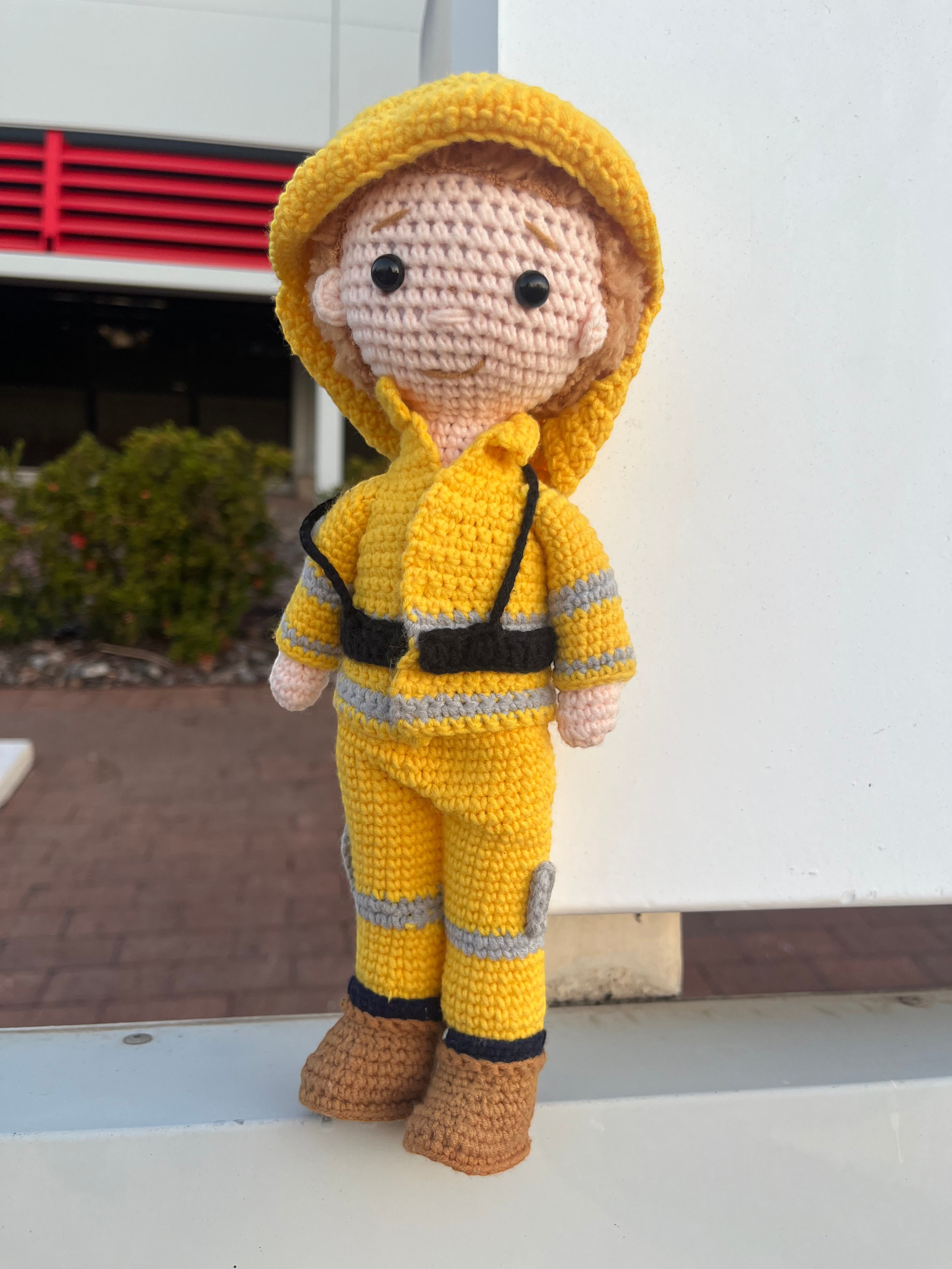 Suzie's Sunshine Dolls handmade crocheted yellow firefighter doll with reflective stripes and brown boots.