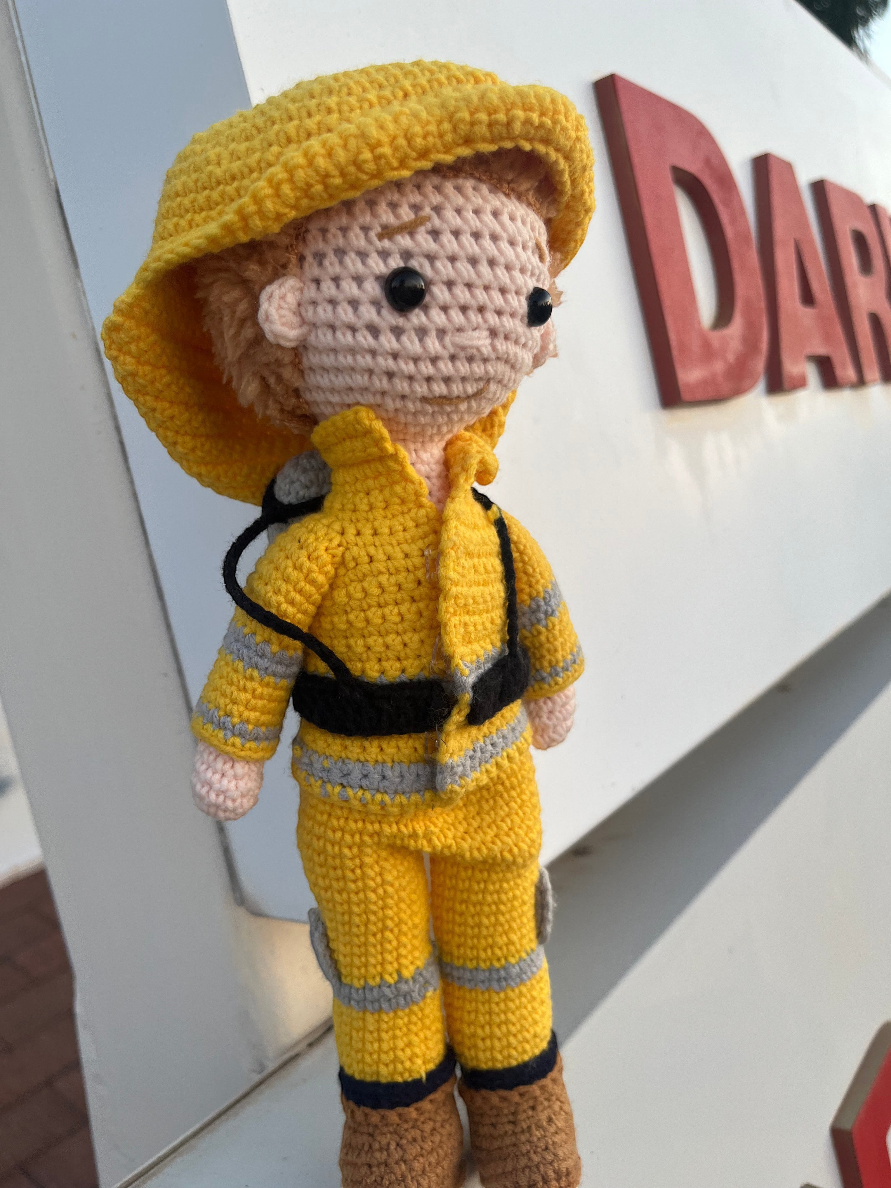 Suzie's Sunshine Dolls handmade yellow crocheted firefighter doll with reflective stripes and brown boots.