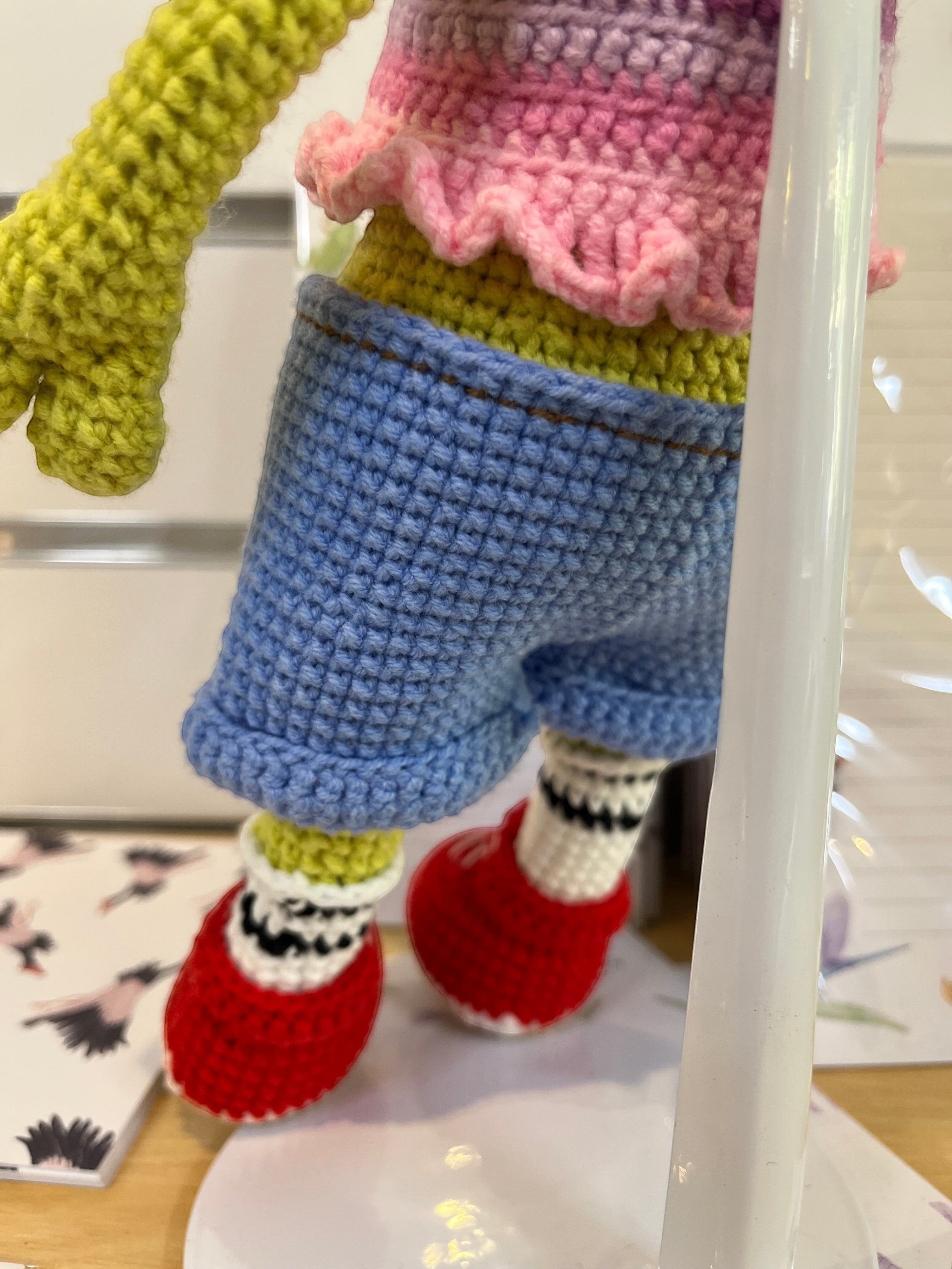Suzie's Sunshine Dolls Frieda the Frog crochet doll with pastel crop top, denim shorts, red shoes, and striped socks.