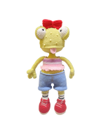 Suzie's Sunshine Dolls Frieda the Frog, a yellow crochet doll with big eyes, red bow, pink crop top, blue shorts, striped socks, and red sneakers.
