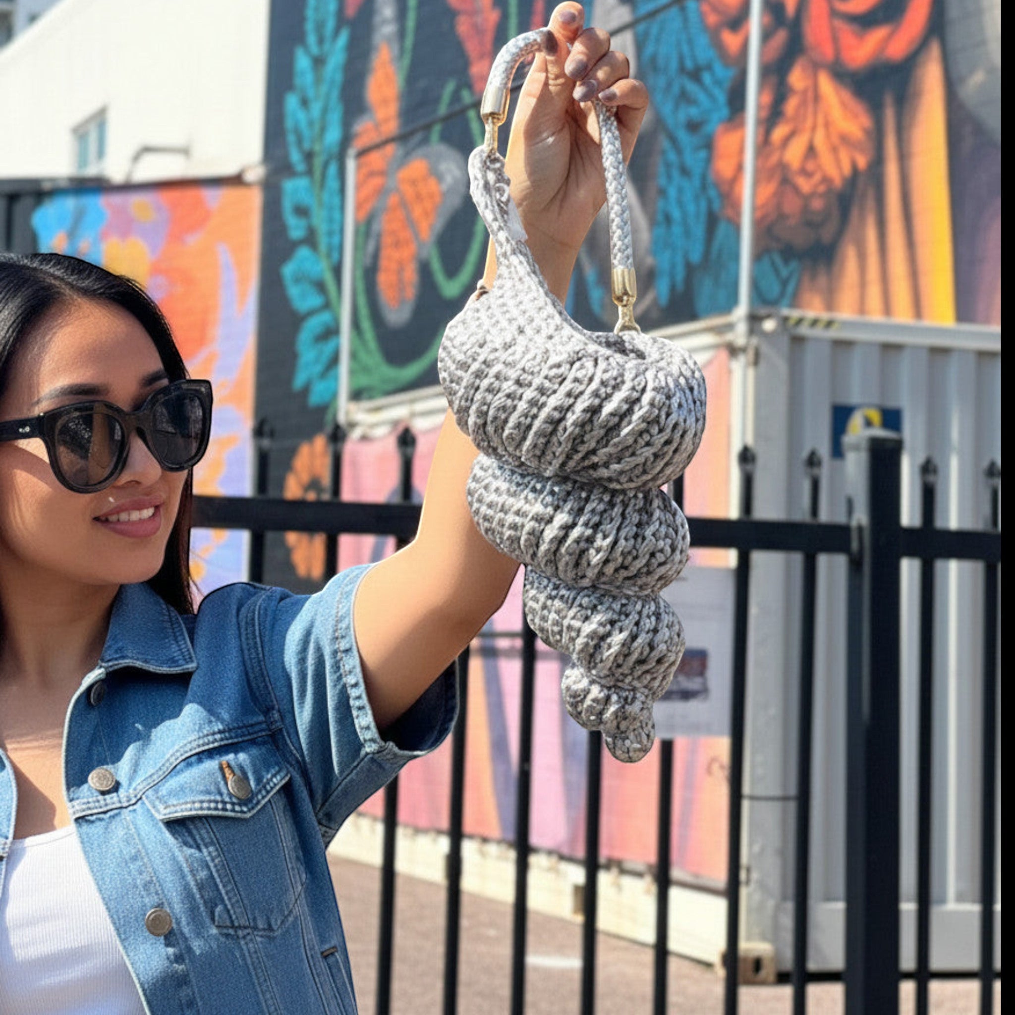 Suzie's Sunshine Dolls grey crochet seashell-shaped bag with braided strap.