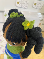 Suzie's Sunshine Dolls handmade doll Leilani with long black curly hair, green and blue flag dress, and green floral accents.