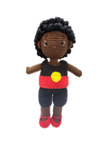 Suzie's Sunshine Dolls Coen, a crochet Indigenous Australian doll with short curly hair, wearing a red, yellow, and black outfit.