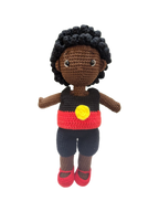 Suzie's Sunshine Dolls Coen, a crochet Indigenous Australian doll with short curly hair, wearing a red, yellow, and black outfit.