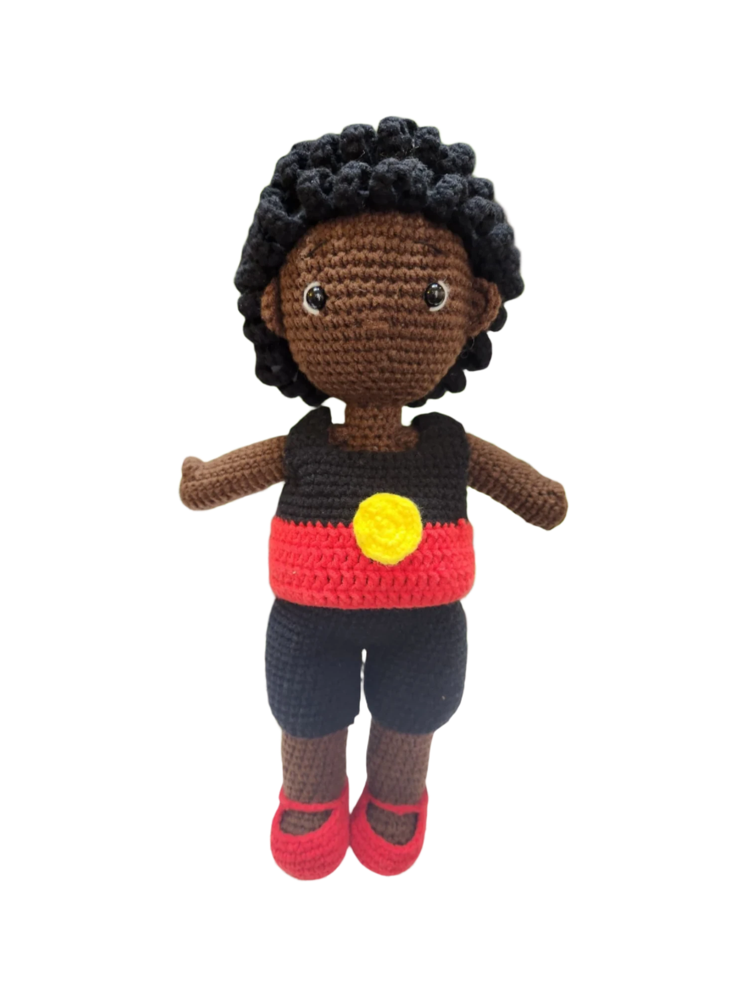 Suzie's Sunshine Dolls Coen, a crochet Indigenous Australian doll with short curly hair, wearing a red, yellow, and black outfit.
