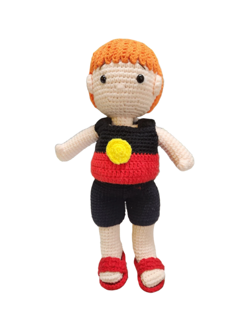 Suzie's Sunshine Dolls Coen, a crochet Indigenous Australian doll with short orange hair, wearing red, black, and yellow outfit.