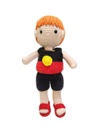 Suzie's Sunshine Dolls Coen, a crochet Indigenous Australian doll with short orange hair, wearing red, black, and yellow outfit.