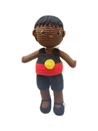 Suzie's Sunshine Dolls Coen, a crochet Indigenous Australian doll with short black hair, wearing a red, yellow, and black outfit.