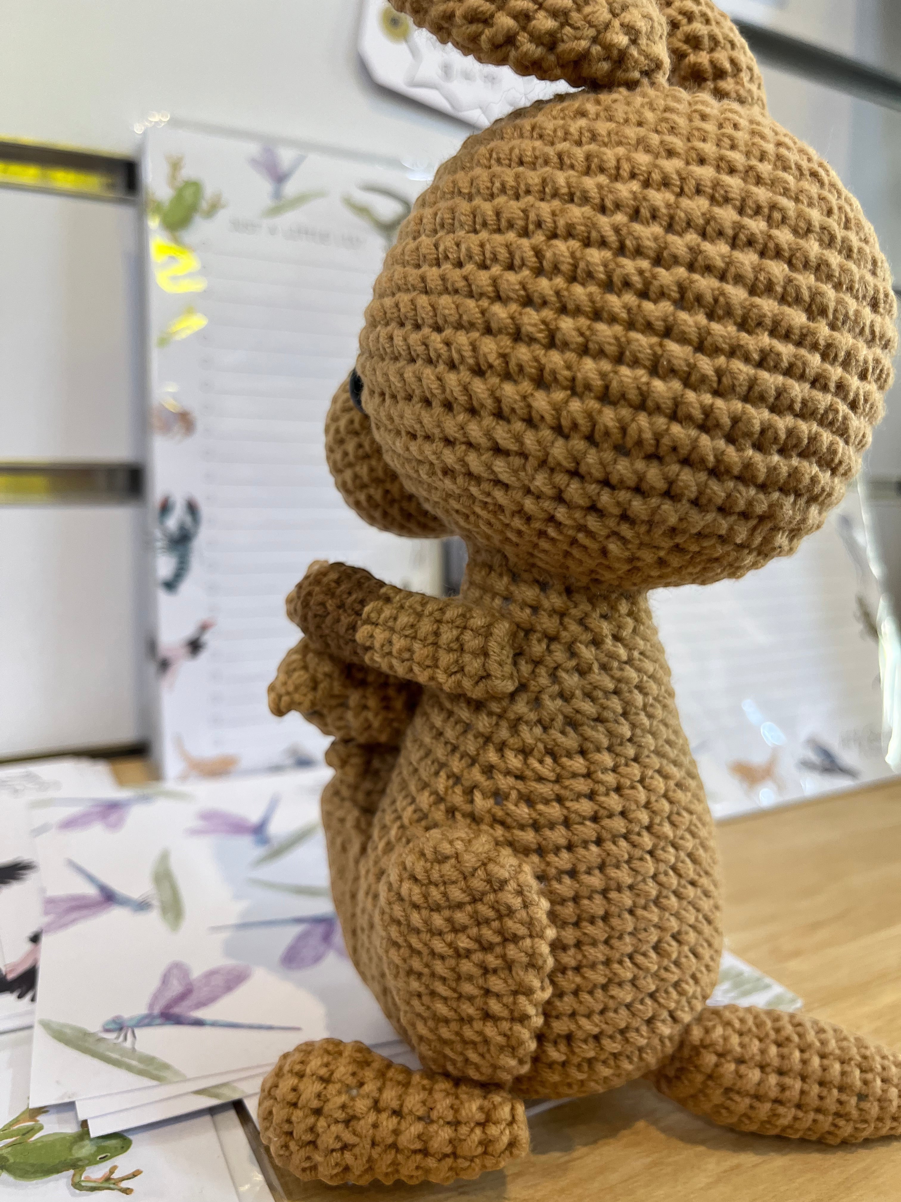 Suzie's Sunshine Dolls Kirsty the Kangaroo, a handmade brown yarn plush toy with a joey in its pouch.