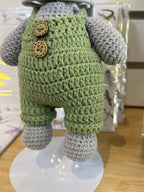 Suzie's Sunshine Dolls Kolby the Koala plush toy in green overalls with wooden buttons and a straw hat.