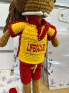 Suzie's Sunshine Dolls crocheted surf lifesaver doll in red shorts and yellow rashie with "LIFEGUARD" patch.
